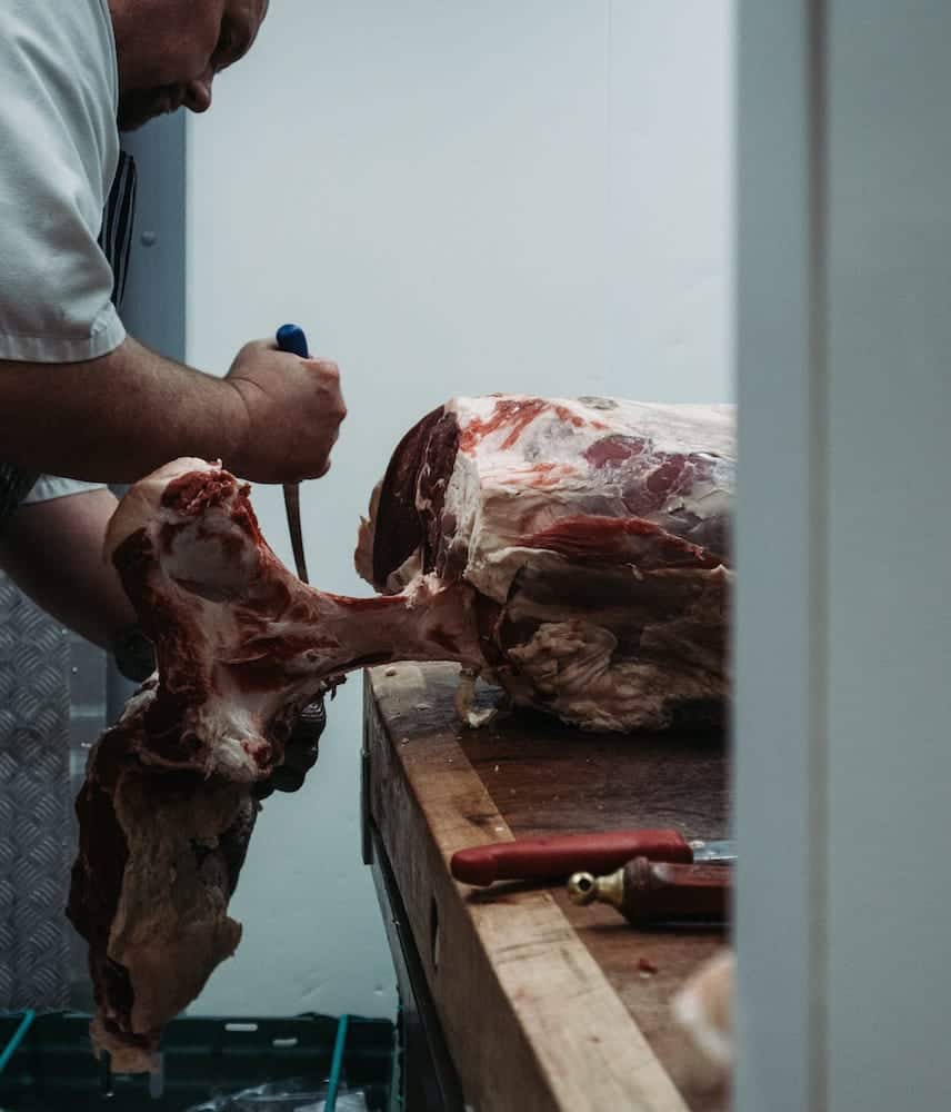 butcher cutting piece of meat