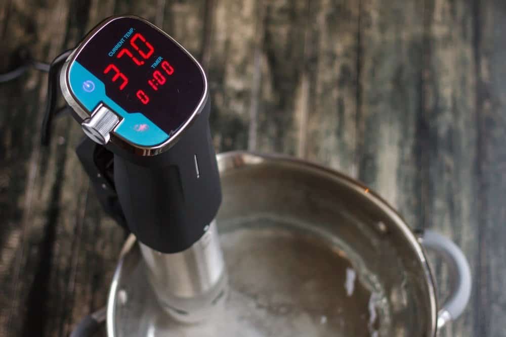 immersion circulator display showing temperature and timer attached to steel pot