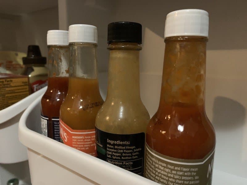 hot sauce bottles in fridge door shelf