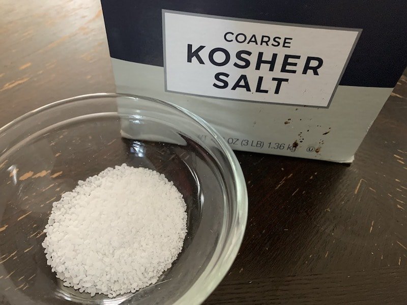 box of kosher salt with small glass bowl with kosher salt next to it