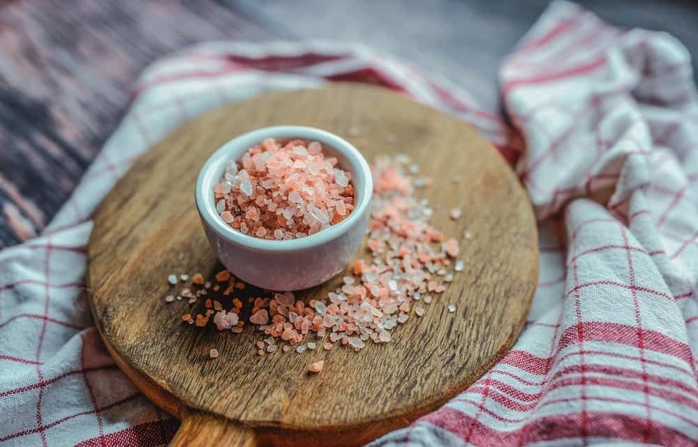 small bowl of pink himalayan sea salt on chopping board