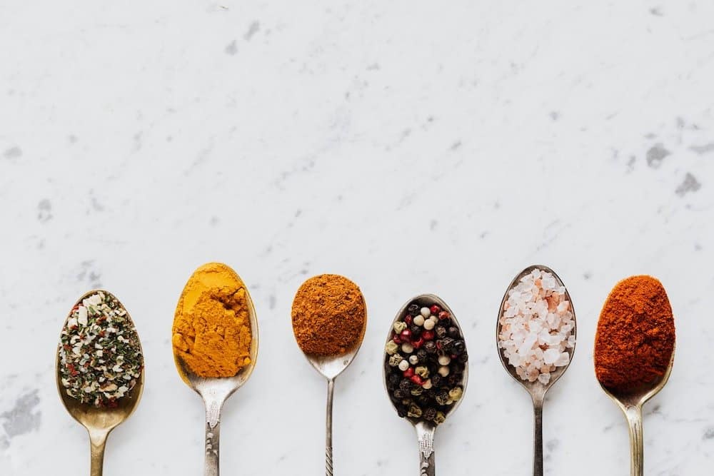 spoons in a row with different types of seasoning in them