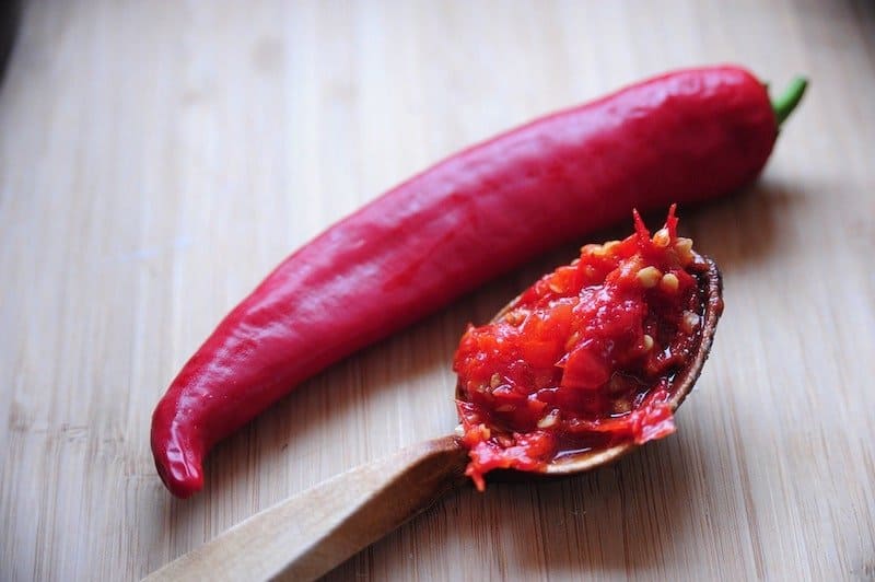 red pepper next to spoon of pepper mash