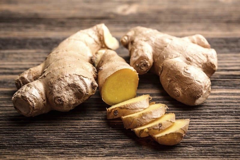 piece of ginger with slices of ginger next to it