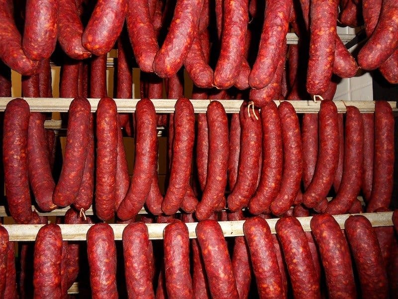 rows of cured sausage hanging to dry