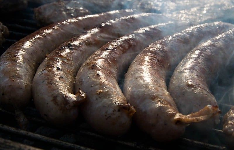 sausages in smoker surrounded by smoke