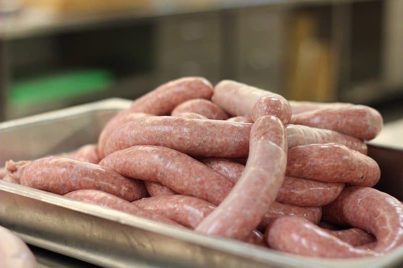 raw sausages piled on scale