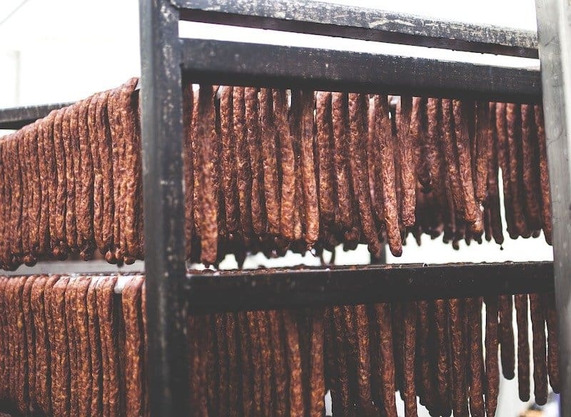 hundreds of sausages hanging in a big smoker