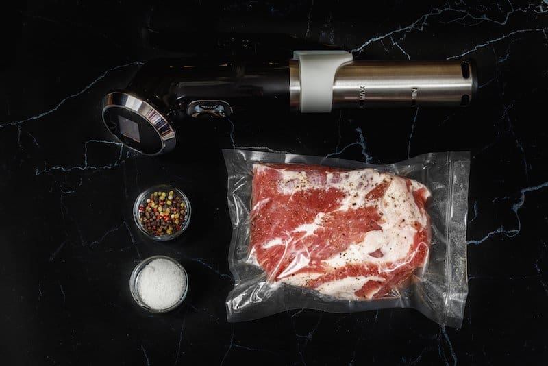 immersion circulatory, two bowls of spices, steak in vacuum sealed bag