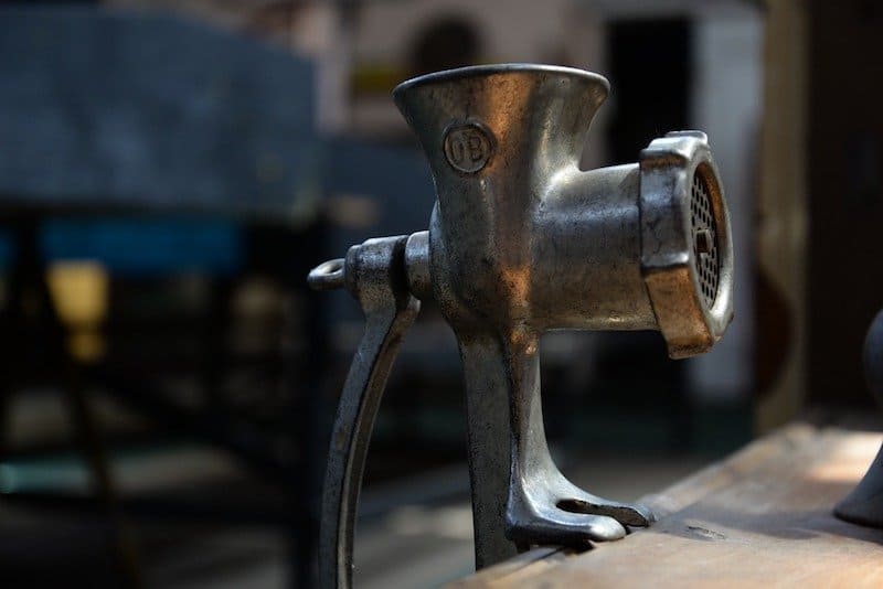 metal meat grinder attached to table