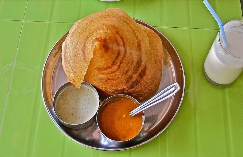 masala dosa on plate with two bowls of chutney