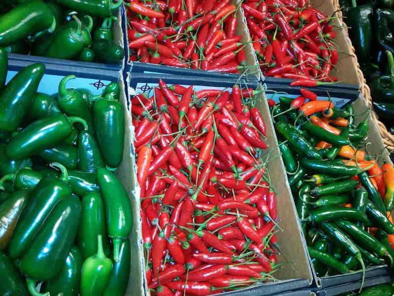 peppers in market three different kinds in different boxes jalapenos red chilis