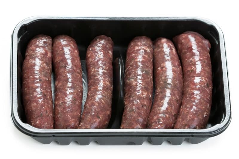 raw venison sausage in plastic tray