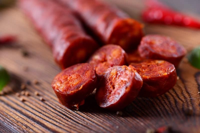 chorizo with chorizo slices on cutting board and red chili pepper