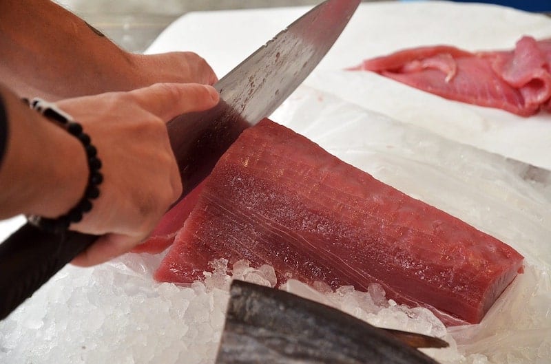 fish monger cutting tuna