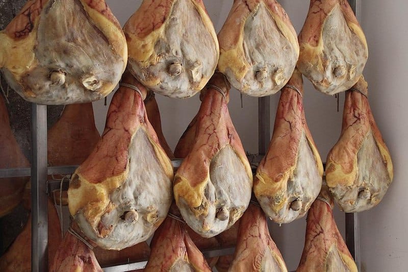 legs of prosciutto hanging to dry