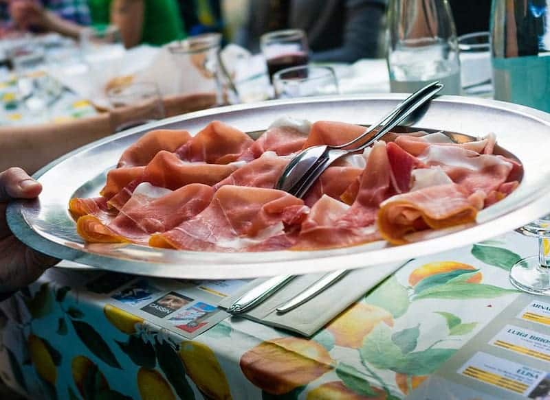 prosciutto slices on plate with fork and spoon