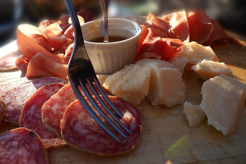 salami slices on charcuterie board cheese board with cheese prosciutto