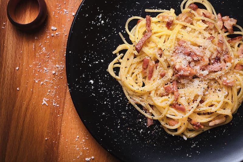 spaghetti carbonara on black plate