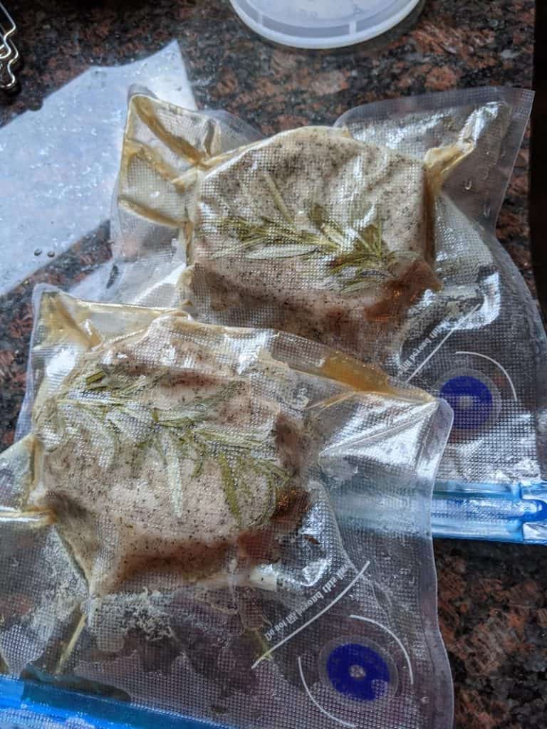 pork chops with rosemary in air tight vacuum sealed sous vide bags