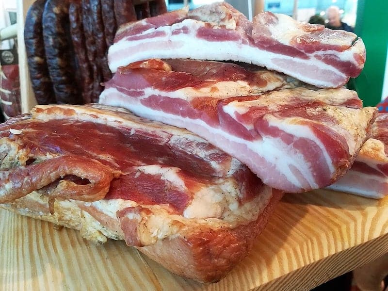 cuts of bacon stacked on table