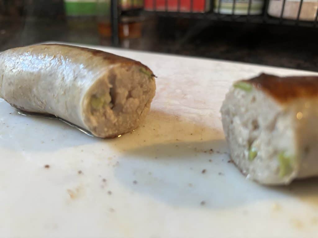 sausage cut in half on cutting board